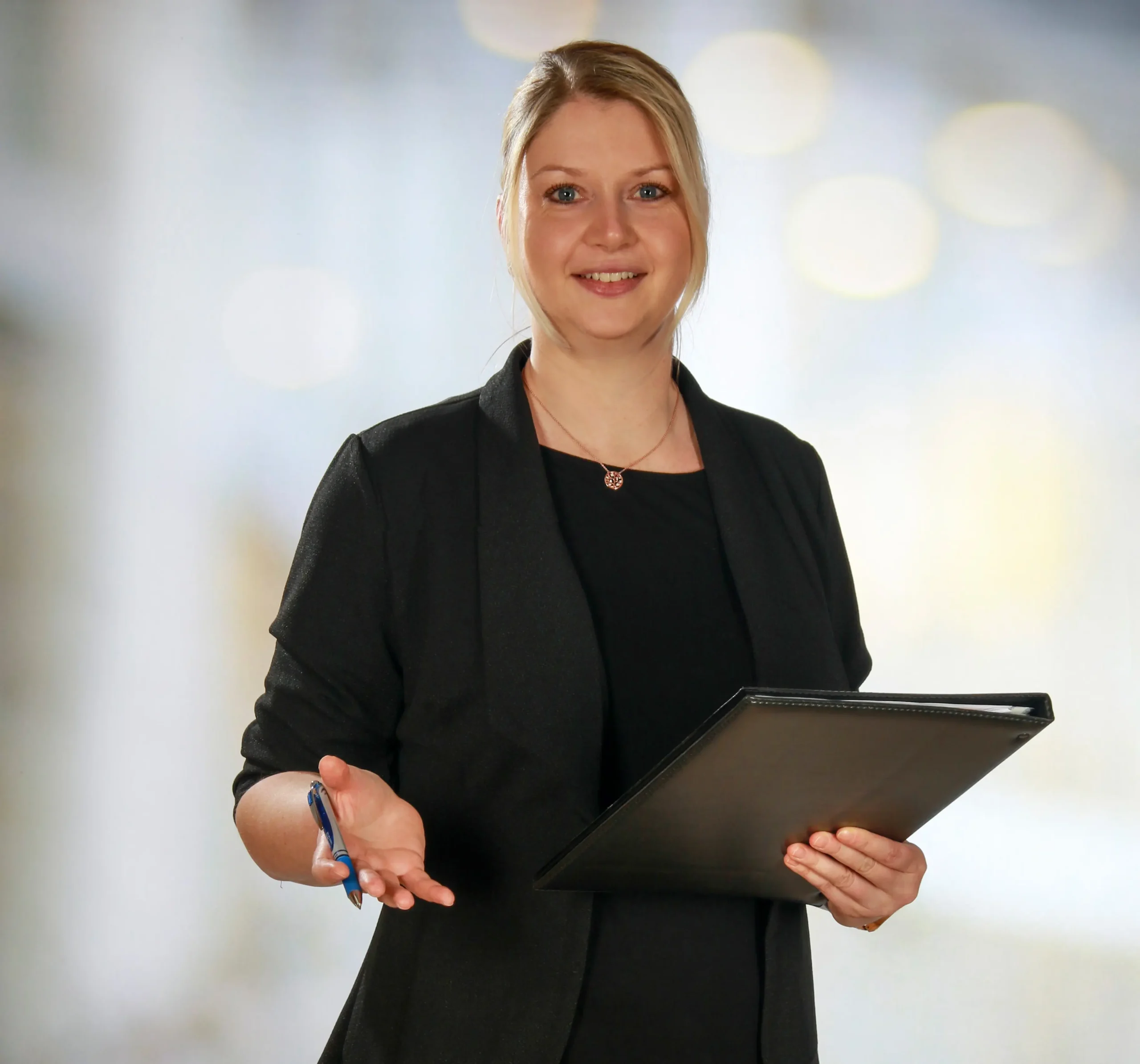 Sandra Roscher mit Schreibmappe im persönlichen Beratungsgespräch für die Energetische Zellanalyse